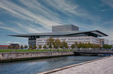 Kopenhag, Danimarka - 14 Eylül 2010: Yeşil Opera Parkı, çimenlik ve yapraklı mavi bulutlar altında Kraliyet Operası 'nın güney cephesi. Tarihi Hristiyanların mavi su kanalı