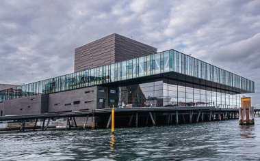 Kopenhag, Danimarka - 14 Eylül 2010: Modern cam ve gri taşlar Kraliyet Tiyatrosu liman suyundan mavimsi bulutların altına yakın çekim