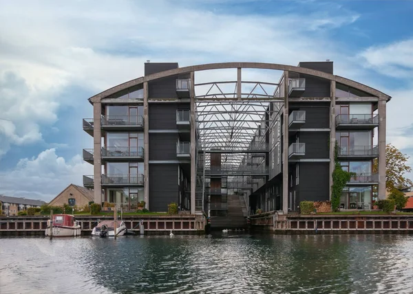 stock image Copenhagen, Denmark - September 14, 2010: Torpedohallen, now luxury flats, built on previous military terrain under blue cloudscape, behind canal water of Christianshavn area. Pleasure boats