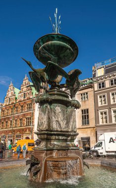 Kopenhag, Danimarka - 15 Eylül 2010: Amagertorv 'daki Stork Fountain heykelinin kapanışı, şehir merkezinde mavi gökyüzüne karşı. Arkaplan olarak tarih ve modern mimari. Yayalar ve kamyonetler