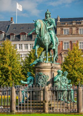 Kopenhag, Danimarka - 15 Eylül 2010: Mavi gökyüzü altındaki Kongens Nytorv 'da Yeşil Bronz Kral V heykel grubu. 