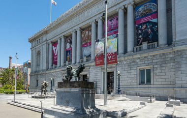 San Francisco, CA, ABD - 12 Temmuz 2023: Asya Sanat Müzesi ön cephesi sütunları ve renkli afişleriyle hazinelerini tanıtıyor. Önde 2 Asya heykeli var.