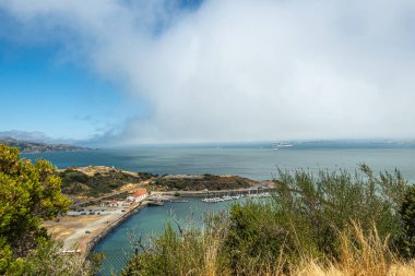 San Francisco, CA, ABD - 12 Temmuz 2023: Presidio Yat Kulübü ile birlikte Golden Gate Köprüsü üzerinde. San Francisco Körfezi 'nde, çok beyaz bir sis altında.