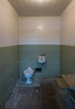 San Francisco, CA, ABD - 12 Temmuz 2023: tarihi Alcatraz hapishanesi. Tuvalet ve lavabodan başka yatağı olmayan hapishane hücresi.