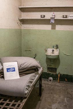 San Francisco, CA, ABD - 12 Temmuz 2023: tarihi Alcatraz hapishanesi. Hücre yatağındaki kurallar ve yönetmelikler el kitabı tuvalet kağıdıyla kapatılacak.
