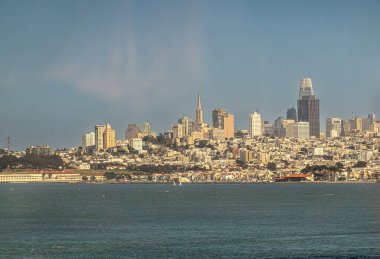 San Francisco, CA, ABD - 13 Temmuz 2023: Şehir manzarası Golden Gate Köprüsü 'nün altından, finans bölgesi merkezde, mavi bulutların altında ve körfez suyu önlerinde görüldü