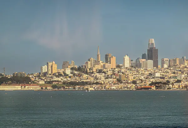 San Francisco, CA, ABD - 13 Temmuz 2023: Şehir manzarası Golden Gate Köprüsü 'nün altından, finans bölgesi merkezde, mavi bulutların altında ve körfez suyu önlerinde görüldü