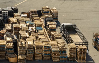 San Francisco, CA, ABD - 13 Temmuz 2023: Bir gemi yükledikten sonra, limandaki sarı veya mavi boş ahşap paletler yığını. Kamyon yüklemeye hazır.