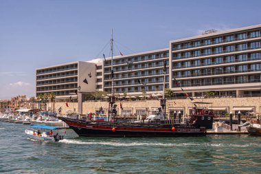 Meksika, Cabo San Lucas - 16 Temmuz 2023 Cabo Korsan Gemisi Günbatımı Akşam Yemeği Gezisi Cabo Legend adlı açık mavi gökyüzü altında Soluksuz Otel binasının önünde. Küçük eğlence tekneleri