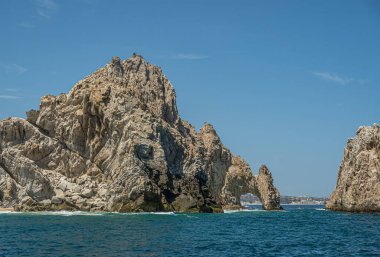 Meksika, Cabo San Lucas - 16 Temmuz 2023 El Arco 'nun güney manzarası Rezerv Los Marina' da uzun kayanın arkasında. Şehir manzarası ve ufukta plaj. Diğer tarafta, küçük turist gezi tekneleri.