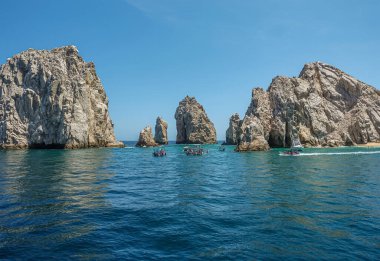 Meksika, Cabo San Lucas - 16 Temmuz 2023: kayalar arasında okyanusu mavi gökyüzünün altındaki körfeze bağlayan Rezerv de Lobos Marinos kanalı. Önde küçük gezi tekneleri var.