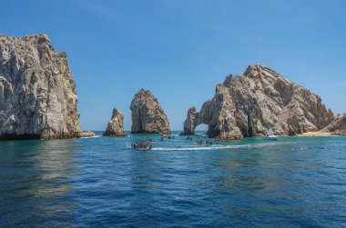 Meksika, Cabo San Lucas - 16 Temmuz 2023 Rezerv de Lobos Marinos 'taki El Arco kayalık kemeri. Okyanustan körfeze geçiş. Önünde bir sürü küçük gezici tekne var.