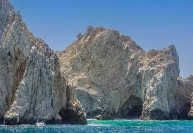 Meksika, Cabo San Lucas - 16 Temmuz 2023 Rezerv de Lobos Marinos 'taki mağaralar, yeşil okyanus suyuna inen gri-bej kayalık kayalıklarda geçtiler.. 