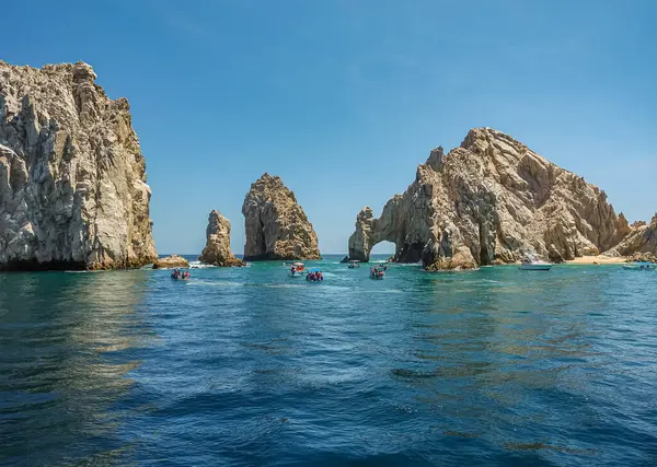 Meksika, Cabo San Lucas - 16 Temmuz 2023 Rezerv Lobos Marinos ve Playa de los Amantes 'teki El Arco kayalık kemeri. Ön tarafta bir sürü küçük gezi teknesi var.