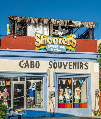 San Jose del Cabo Centro, Meksika - 16 Temmuz 2023: Cabo Hediyelik Eşya Dükkanı 'nın üst düzey Shooters spor barı ve mavi gökyüzünün altında ızgara ile renkli cephe