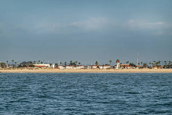 美国加利福尼亚州文图拉市 2023年9月14日 文图拉港的白色建筑和红色屋顶被蓝天下的海洋看到 中间的绿色棕榈树 前面的沙滩 — 图库照片