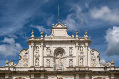 Guatemala, La Antigua - 20 Temmuz 2023: San Jose katedralinin tepesinde mavi bulutlara karşı pek çok aziz heykeli bulunan beyaz taş bina