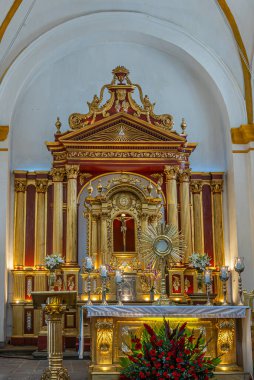 Guatemala, La Antigua - 20 Temmuz 2023 San Jose Katedrali. Tarihi sunak nüshasına sahip bir şans ve önünde büyük bir heykel bulunan yeni bir sunak. Her yer altın rengi ve kırmızı çiçekler.