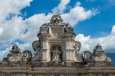 Guatemala, La Antigua - 20 Temmuz 2023 Koloni Sanat Müzesi. Mavi bulutların altında, kuzey giriş kapısının üzerinde geniş bir heykel yapısı var.