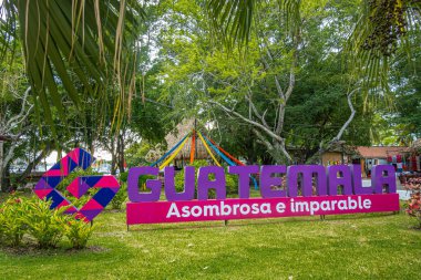 Guatemala, Puerto Quetzal - 20 Temmuz 2023: Asombrosa e Inparable, Amazing ve Durdurulamaz sloganlı dev renkli ülke işaretiyle terminal yeşil parkında dolaşın