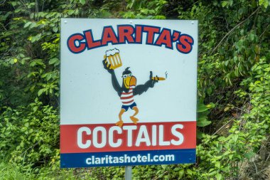 Kosta Rika, Cero Bajo - 22 Temmuz 2023: Claritas Otel ve barına yakın çekim, Rotonda del Agricultor Costarricense 'in güneyinde, 34. karayolunda siyah sigara ve bira içilen papağan resmi 