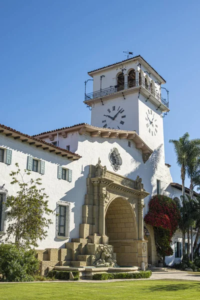 アメリカ合衆国カリフォルニア州サンタバーバラ2023年11月30日 サンタバーバラ郡庁舎は 白い石と白い時計の展望塔を青空に設定した壮大なアーチを展示しています 植物と木 — ストック写真
