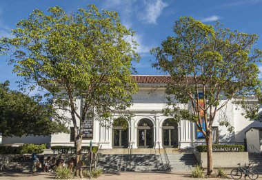 Santa Barbara, CA, ABD - 30 Kasım 2023: Sanat Müzesinin ön cephesi. İnsanlar banklarda, bitkilerde ve ağaçların önünde, mavi gökyüzünün altında