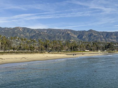Santa Barbara, CA, ABD - 27 Ocak 2024: Stearns Wharf 'tan görüntü. Pasifik Okyanusu 'nda Mission Creek' in boşaltıldığı doğu sahili. Santa Ynez dağ sırası ve palmiye ağaçlarının arkasındaki riviera
