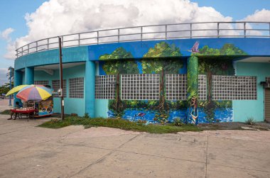 Kosta Rika, Puntarenas - 22 Temmuz 20.23: Anfiteatro Kültür La Concha Acustica Meydanı. Sokak satıcıları ve tekstil dükkanı. Yeşil yaprakların, mavi bulutların ve Nicoya Körfezi 'nin arkasındaki iskelede bir gemi.