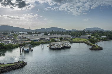Panama Kanalı, Panama - 24 Temmuz 2023: Corozal Oeste Landing, ulusal kasırga ve hava tahmini merkezi, kısa yeşil çimenlik rıhtımları mavi bulutlar altında yanaşmış küçük tekneleri koruyor