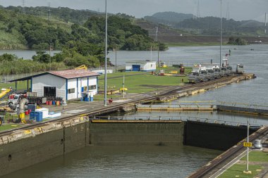 Panama Kanalı, Panama - 24 Temmuz 2023: Kapanış, Miraflores sol odayı kilitliyor çıkış ve kapılar, mavi bulutların altındaki yeşil kıyı şeridi...