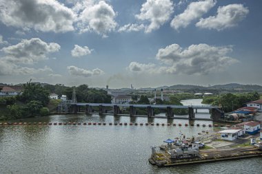 Panama Kanalı, Panama - 24 Temmuz 2023: Mavi bulutların altında yüksek bacaları olan termoelektrik santrali. Doğu Miraflores 'in çoğu iskeleyi traktörle kilitler.