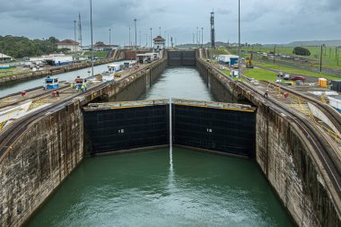 Panama Kanalı, Panama - 24 Temmuz 2023: Atlantik 'e giden 2 ve 3 numaralı odalar arasında kapılar kapanıyor. Mavi bulut manzarası. İşçiler, raylar, binalar, kuleler, ışıklar ve rıhtımlarda daha fazlası