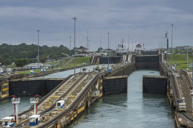 Panama Kanalı, Panama - 24 Temmuz 2023: Gatun kapanıyor, güle güle Panama Kanalı, Atlantik kıyılarına ve su seviyelerine ulaşıyor. Mavi bulut manzarası. Gemi çekme traktörü üsse dönüyor.