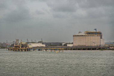 Limon Körfezi, Kolon, Panama - 24 Temmuz 2023: Gri bulutlar altında gemilerin fosil yakıtları boşaltması için ana yapı ve iskele olan AES Colon elektrik santrali veya Termoelectrica.