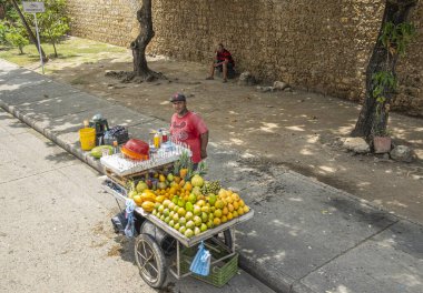 Cartagena, Kolombiya - 25 Temmuz 2023: Ambulans meyve ve içecek satıcısı Whit el arabası. 
