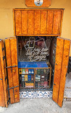 Cartagena, Colombia - July 25, 2023: Liqour store in Calle 30 has counter in street side display window. Bottle boxes on display  clipart