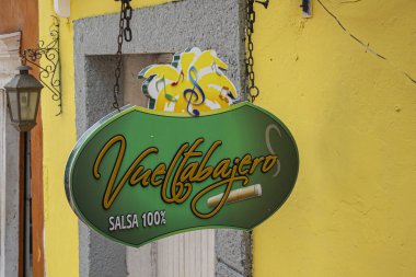 Cartagena, Colombia - July 25, 2023: Colorful artsy Vueltabajero Salsa 100% sign closeup of cultural space in Calle 30 where Afro-Caribbean music, food, smokes and more are enjoyed.  clipart
