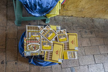 Cartagena, Colombia - July 25, 2023: Cohiba premium Cuban cigars on sale out of blue bag in old town street by unregulated street vendor. clipart
