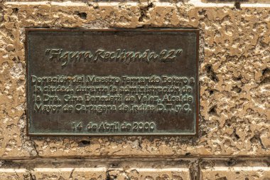 Cartagena, Kolombiya - 25 Temmuz 2023: Kahverengi taş üzerinde metal plaket San Domingo Meydanı 'ndaki Figura Reclinada heykelinin yaratıcısı Fernando Botero