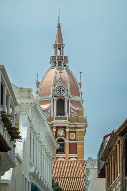 Cartagena, Colombia - July 25, 2023: Cathedral de Santa Catalina de Alejandra. Closeup, Monumental yellow wals, white trims and dome-shaped top of main cathedral tower seen from south clipart