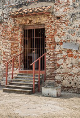 Cartagena, Kolombiya - 25 Temmuz 2023 Baluarte de San Ignacio surları ve kalesi üzerindeki kilitli kapı, tarihi beton ve kırmızı tuğlalardan oluşan duvar. Yukarı ve kırmızı ızgara