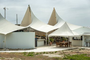 Cartagena, Kolombiya - 25 Temmuz 2023: Merkez Bocagrande Carrera. Beyaz çadırların altında bar restoranı olan Kala Plaj Kulübü.