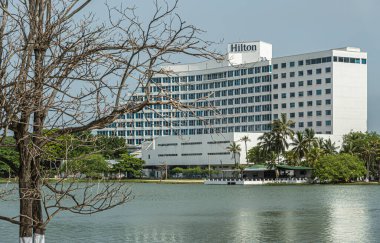 Cartagena, Kolombiya - 25 Temmuz 2023: Merkez Bocagrande. Hilton Oteli, El Laguito 'nun güney yakasında yeşil su ve yeşil yapraklarla çevrili.