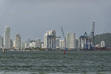 Cartagena, Kolombiya - 25 Temmuz 2023 Bocagrande. Santa Cruz de Castillogrande Kalesi 'nden kuzeye bakıyor. Ana karadaki konteynır terminalinin bir kısmı ve uzun beyaz bina