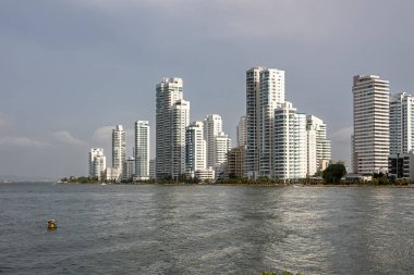 Cartagena, Kolombiya - 25 Temmuz 2023 Santa Cruz de Castillogrande Kalesi 'nden sola dönen Peinsula. Batıdan gelen güneş, koyu körfez ve mavi-gri gökyüzü arasında.