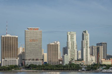Miami, Florida, ABD - 29 Temmuz 2023: Biscayne Bulvarı boyunca One Biscayne Tower 'dan NE 4. Cadde' ye mavi gökyüzü altında. Yeşil Bayfront Parkı kıyı şeridi boyunca