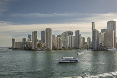 Miami, Florida, ABD - 29 Temmuz 2023 Brickell Key Adası 'nın yüksek binalarının duvarı akşam gökyüzü altında Kraliyet Prensesi' nin yatıyla seyahat ediyor. Yakınlarda küçük yatlar, nehir ağızlı.