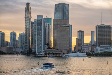 Miami, Florida, ABD - 29 Temmuz 2023: River mouth 'tan Bayfront Park' a kadar uzanan kıtalararası otel ve deniz havzası yatı ile akşam 19: 45 'te ana kara silueti.