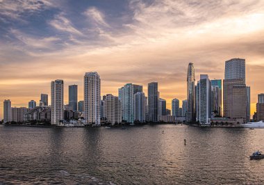Miami, Florida, ABD - 29 Temmuz 2023: 19: 42 'de Brickell Key adasında ve anakarada yüksek binalar. Sahildeki Tequesta noktaları arasındaki Centinel heykeli.